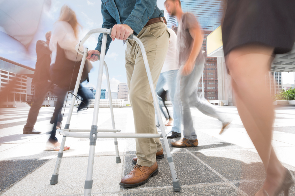 A man using a walker on a busy street to avoid falling in Texas.