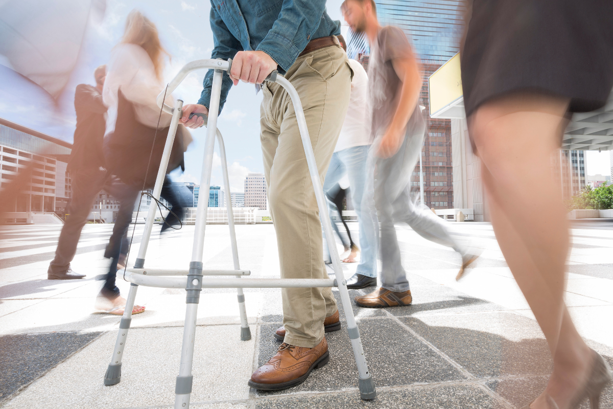 A man using a walker on a busy street to avoid falling in Texas.