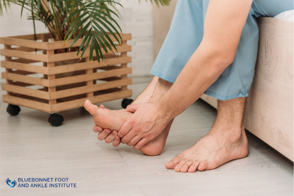 A man living with gout is holding his foot in pain while sitting in Austin, Texas.